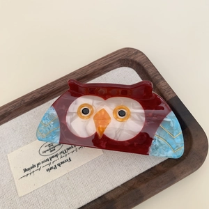 Artistic owl-shaped hair claw clip in deep red and blue marble acetate finish