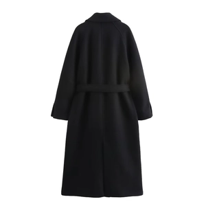 Detail view of the back of a black long wool coat with matching waist belt and back slit