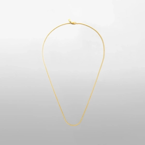 Detailed view of glossy gold snake bone chain with secure lobster clasp and flat tag