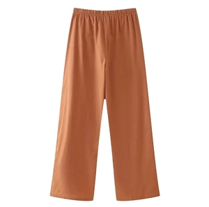 Detailed view of caramel brown wide-leg trousers with elastic waist on white background