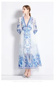 Détail de l'encolure en V et motifs floraux bleus sur la robe blanche à manches longues