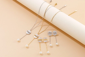Detailed view of pearl jewelry set with shell pendants and LOVE letter engravings