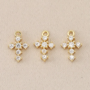 Macro detail of 18K gold plated Baroque cross pendants with sparkling crystal inlay