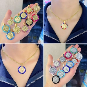 Dettaglio del ciondolo medaglia di San Benedetto con perline colorate in finitura oro e argento