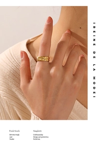 Close-up of golden stainless steel ring with wheat pattern texture on a finger