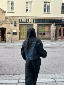 Vue de dos style urbain d'une veste en jean bleu foncé et d'un pantalon évasé noir