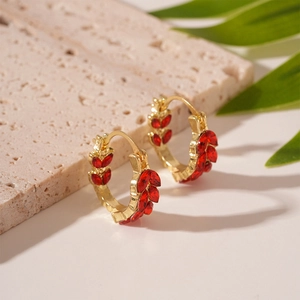 Detailed macro view of golden wheat ear hoop earrings with marquise red gemstones