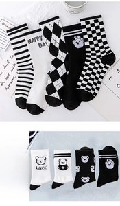 Detail showing white crew socks with black bear embroidery and lucky text patterns