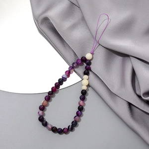 Detail of purple agate beaded phone strap with hand-woven loop on silk background