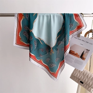 Detail of silk-like scarf featuring paisley and harness prints on a metal hanger