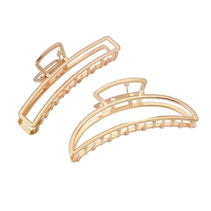 Close-up of golden hollow geometric hair claws in rectangular and semi-circle metal design