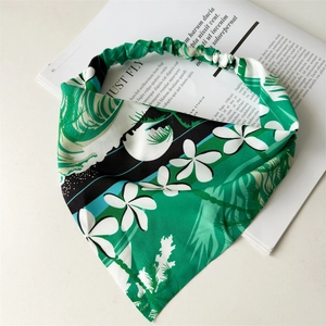 Close-up of tropical palm and plumeria leaf print headband with elastic band detail