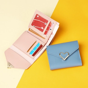 Short tri-fold wallet details showing internal card slots and heart buckle design