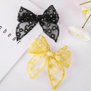 Detailed view of yellow and black floral embroidered daisy lace bow hair clips for girls