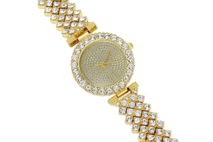 Close-up of golden ladies watch with round dial and sparkling crystal rhinestones