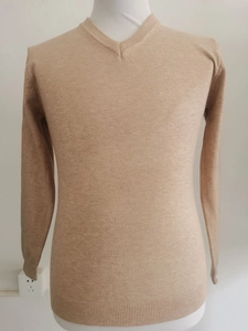 Detailansicht eines V-Ausschnitt-Pullovers in Apricot mit Rippstrick an Kragen und Saum