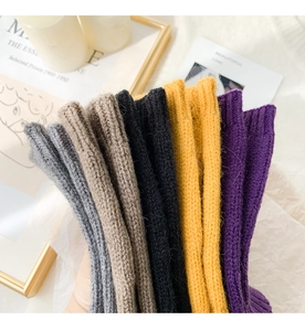 Close-up of assorted colorful knitted fingerless gloves in gray beige black and purple