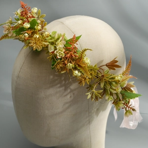 Detailed close-up of a floral wreath headband featuring green leaves and orange blossoms
