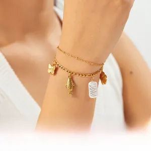 Close-up of double-layer gold-plated bracelet with butterfly and pearl charms on wrist