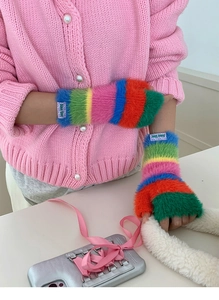Détail de gants en peluche arc-en-ciel avec texture de fausse fourrure douce