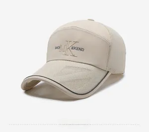 Detail view of beige mesh baseball cap featuring MO M K EKEND embroidery and black brim piping