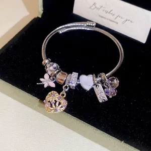 Silver charm bracelet with pink enamel flower and heart pendants in a velvet box