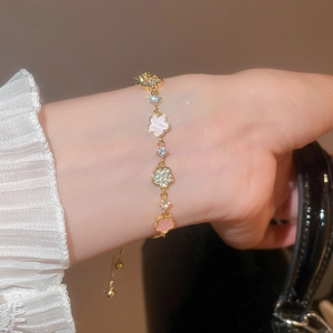 Detail of adjustable gold flower bracelet with zircon stones and acetate petals