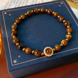 Détail des perles naturelles en oeil de tigre et des perles intercalaires dorées chic