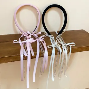 Pink and black fabric headbands with long satin ribbons and beaded tassel accents