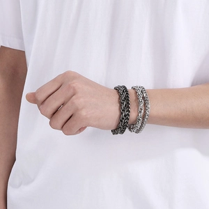 Close-up of double-layer stainless steel Cuban chain bracelets for men in silver and black