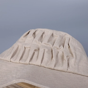 Elegant beige linen sun hat for women with pleated details and breathable fabric texture