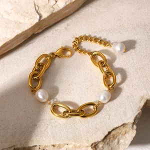 Macro detail of 18K gold stainless steel thick chain bracelet with baroque white pearls