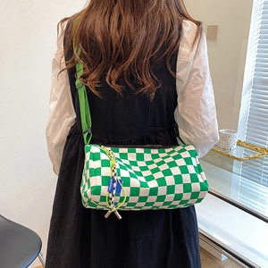 Green and white checkerboard Boston bag with adjustable strap shown on model back