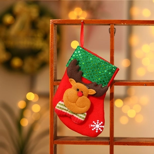 Gros plan d'une chaussette de Noël en feutre rouge avec renne 3D et paillettes vertes
