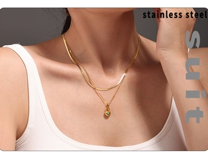Close-up of double layer gold necklace with turquoise heart pendant on a model
