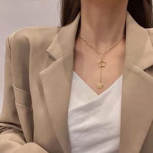 Minimalist gold star tassel pendant necklace in titanium steel on a fashion model