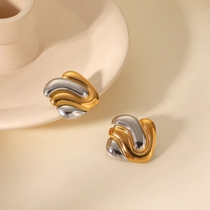 Detailed view of bicolor geometric wave earrings with polished gold and silver finish
