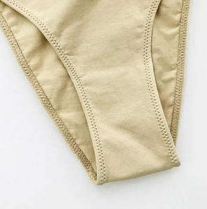 Macro detail of breathable cotton crotch with zigzag stitching on beige panties