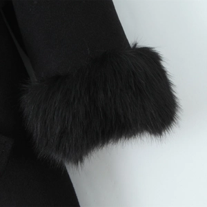 Detail of the black coat sleeve featuring premium faux fur trim and wool fabric texture