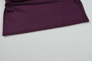 Detailed view of the dark purple dress hem featuring neat double-needle stitching