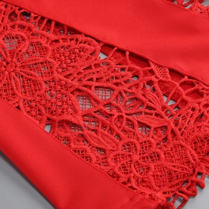 Gros plan sur la dentelle rouge aux motifs floraux complexes et texture maille détaillée