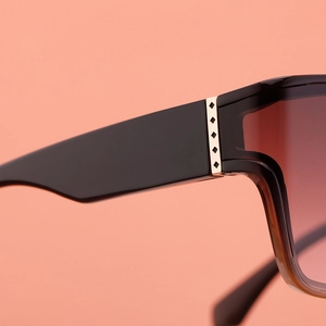 Detail of square sunglasses with gradient lenses and gold-toned metal temple accents