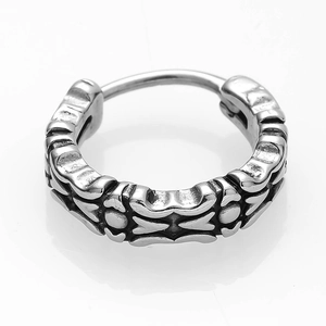 Macro detail of silver vintage-style earrings with retro embossed pattern on steel