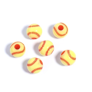 Macro detail of yellow acrylic baseball beads with red stitching for DIY jewelry making