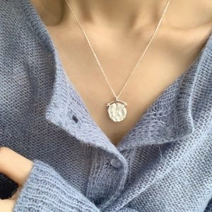 Collana con ciondolo a moneta martellata in argento sterling 925 indossata da modella