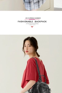 Black PU leather backpack detail with silver zippers on a model in a red T-shirt