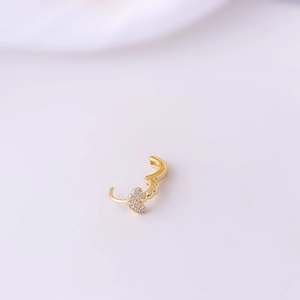 Golden micro-pave zircon heart drop earrings on soft pink fabric background