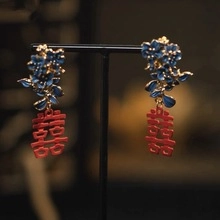 Dettaglio di orecchini cinesi Doppia Felicità con fiore in smalto blu e pendente