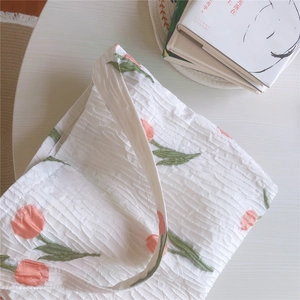 Détail du sac en toile seersucker blanc avec motif floral de tulipes orange imprimé