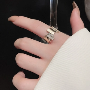 Macro shot of gold-plated geometric ring with zircon and shell inlay on a model hand